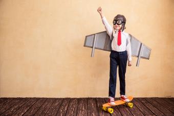 child on skate board wearing wings