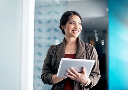 A lady smiling and using tab looking to that side